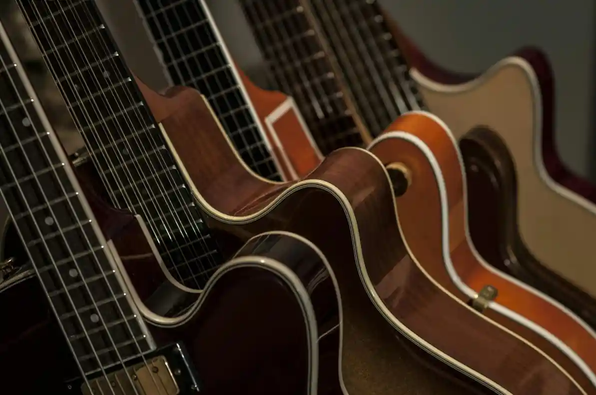Studenci po odebraniu dyplomów Zbiór 4 gitar ułożonych kolejno w artystycznym kadrze.