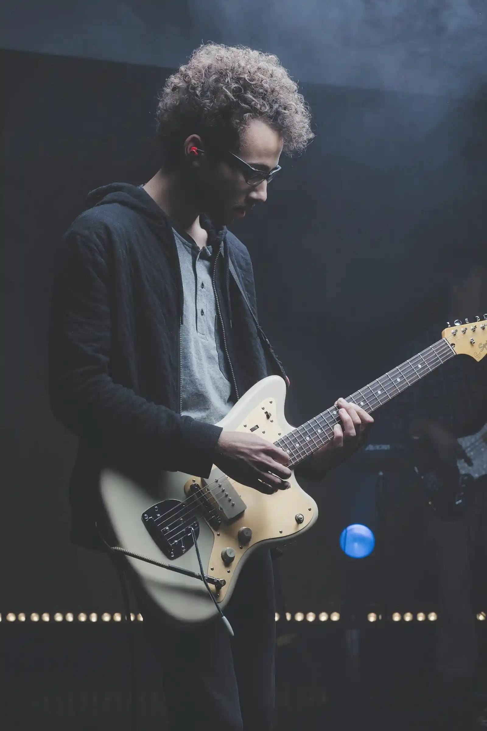 Brytyjska budka telefoniczna Młody gitarzysta gra na miętowej gitarze elektrycznej squier jazzmaster.
